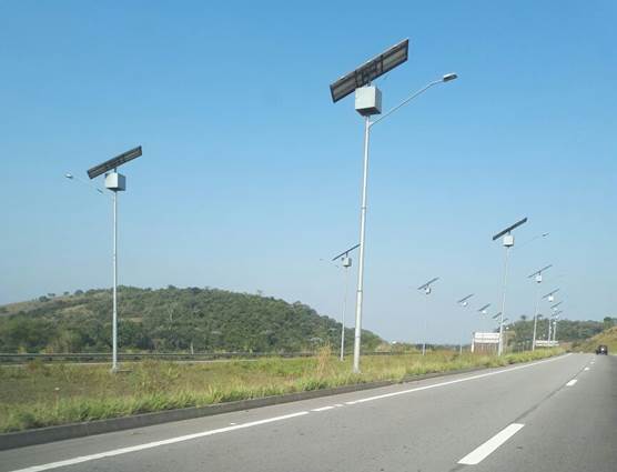 Foto de estrada com postes que possuem placas solares